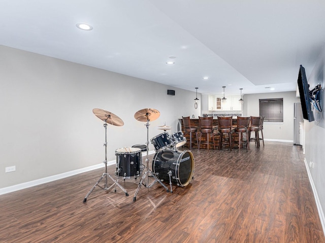 game room with recessed lighting, baseboards, indoor bar, and dark wood-style flooring