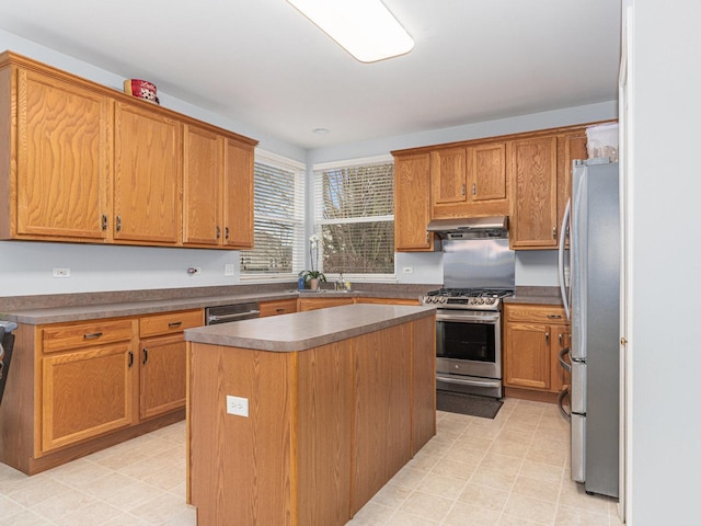 kitchen with a sink, dark countertops, a center island, ventilation hood, and appliances with stainless steel finishes