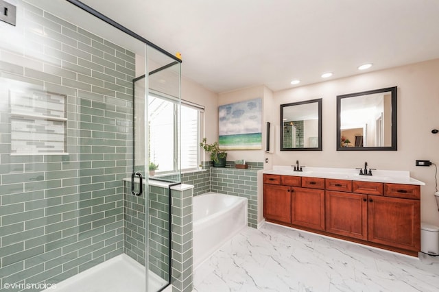 bathroom with a shower stall, a garden tub, double vanity, marble finish floor, and a sink