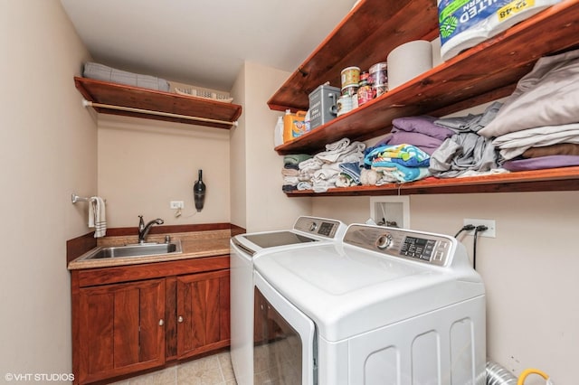 laundry room with cabinet space, washer and dryer, and a sink