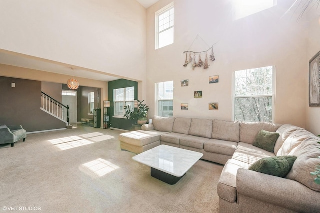 carpeted living room featuring stairway and baseboards