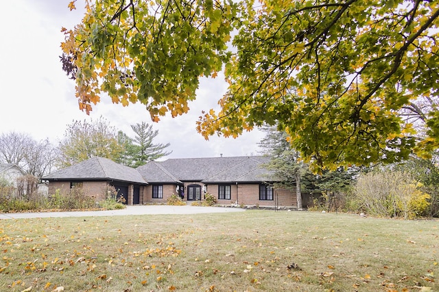 ranch-style house featuring brick siding and a front yard