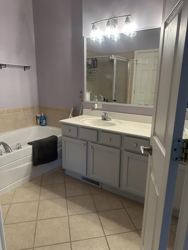 bathroom with visible vents, a stall shower, a bath, tile patterned floors, and vanity