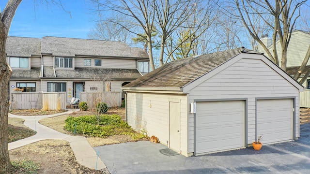 detached garage featuring fence