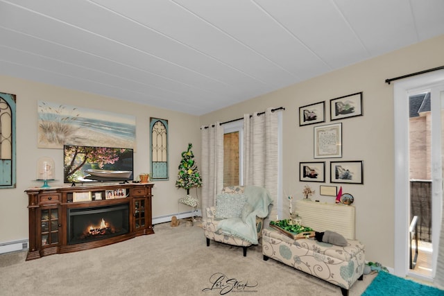 living area with a baseboard radiator, a lit fireplace, a baseboard heating unit, and carpet flooring