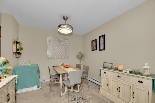 dining room with light carpet and baseboard heating