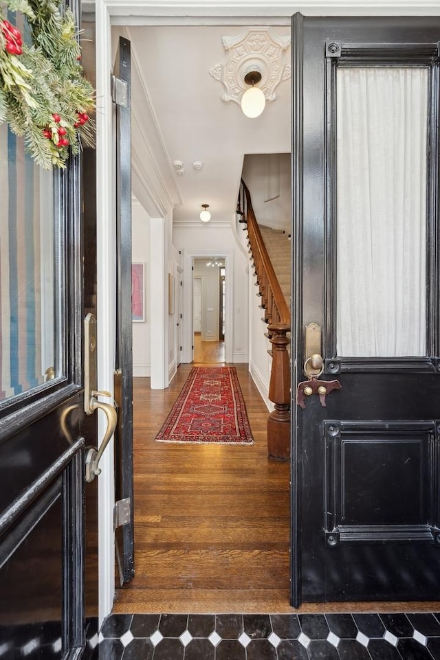 entrance foyer featuring stairway, baseboards, and ornamental molding