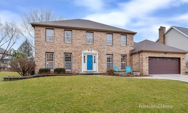 colonial inspired home with a front lawn, an attached garage, brick siding, and driveway