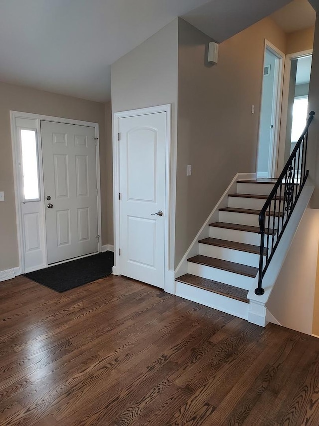 entrance foyer with stairs, dark wood-style floors, and baseboards