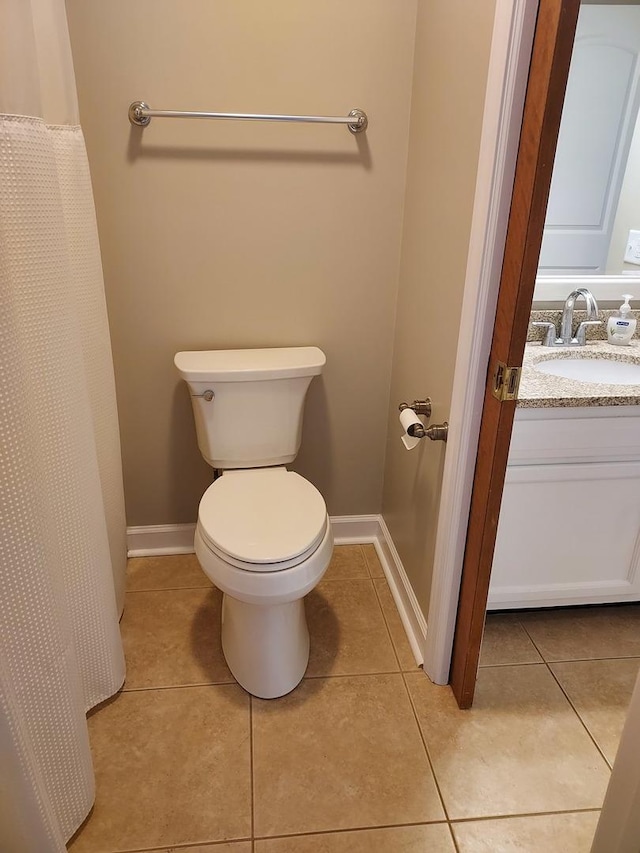 full bathroom with vanity, tile patterned floors, toilet, and baseboards