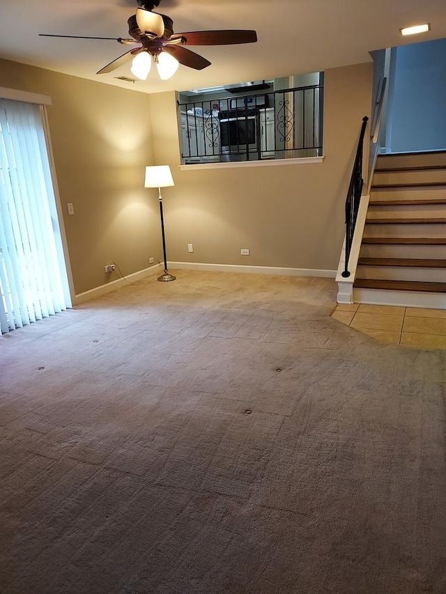 unfurnished living room featuring baseboards, stairs, ceiling fan, and carpet floors