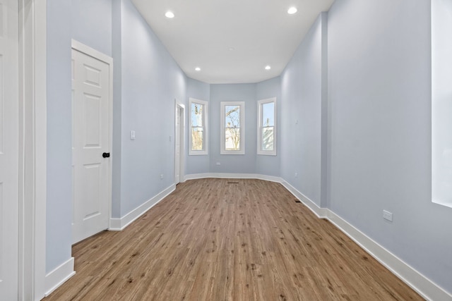 empty room with recessed lighting, baseboards, and wood finished floors