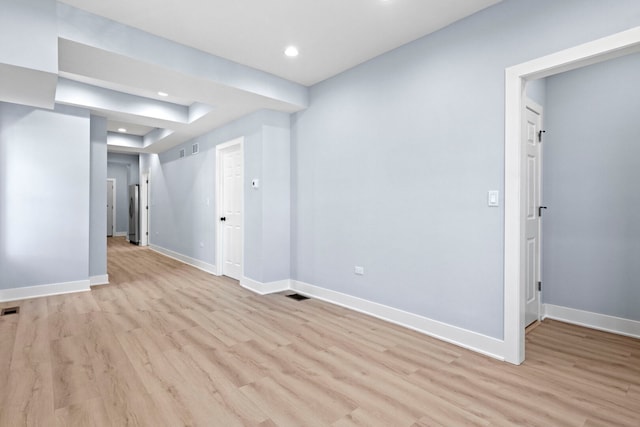 empty room with visible vents, recessed lighting, baseboards, and light wood finished floors