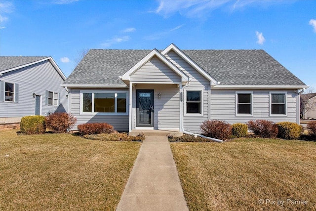 view of front of home with a front yard and roof with shingles