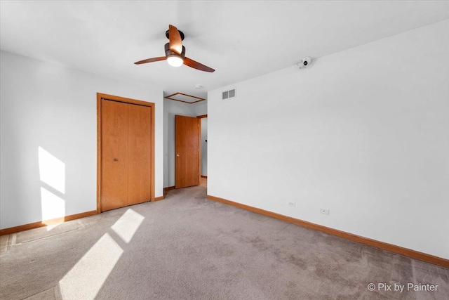 unfurnished room with visible vents, carpet flooring, a ceiling fan, and baseboards