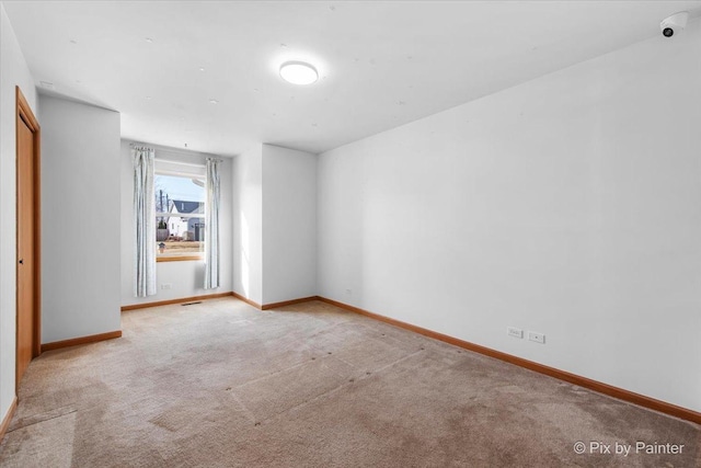 carpeted empty room with baseboards