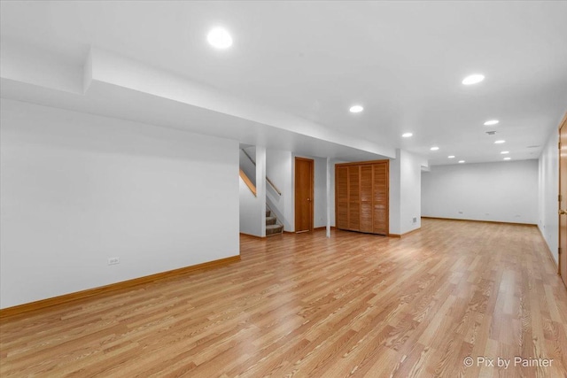 finished below grade area featuring recessed lighting, light wood-style flooring, stairs, and baseboards