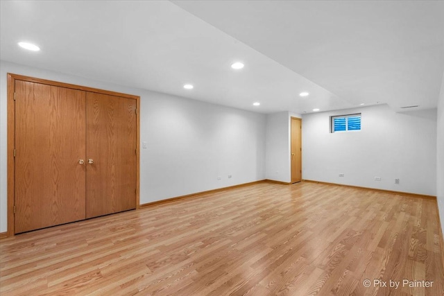 finished below grade area with recessed lighting, light wood-type flooring, and baseboards