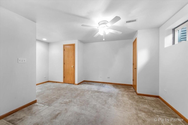 unfurnished room with carpet flooring, baseboards, visible vents, and ceiling fan