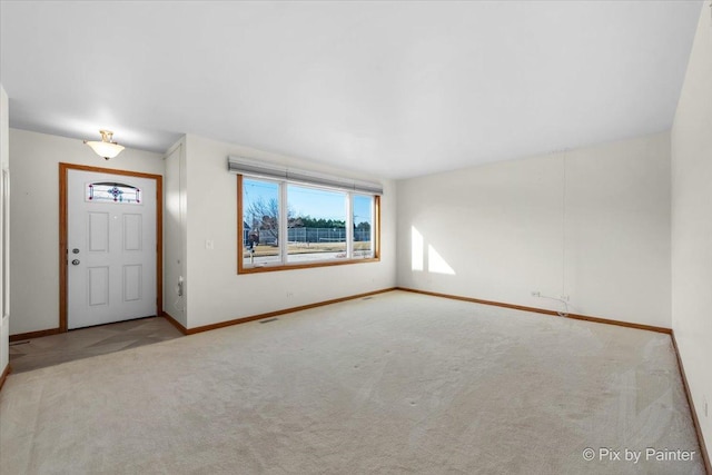 carpeted entrance foyer with baseboards and visible vents