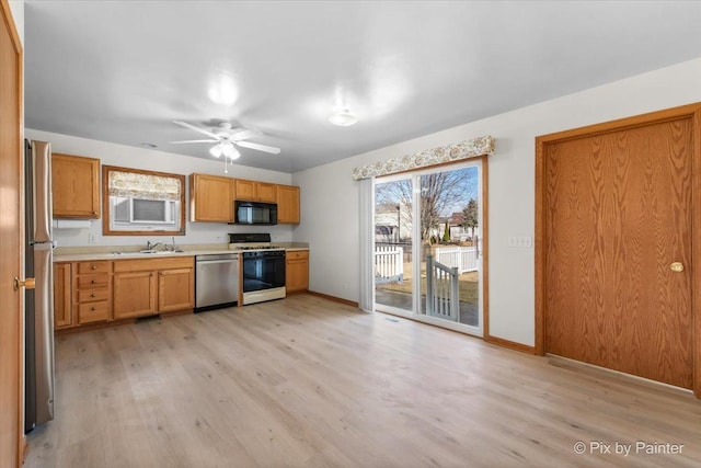 kitchen featuring baseboards, light countertops, appliances with stainless steel finishes, light wood-style floors, and a ceiling fan