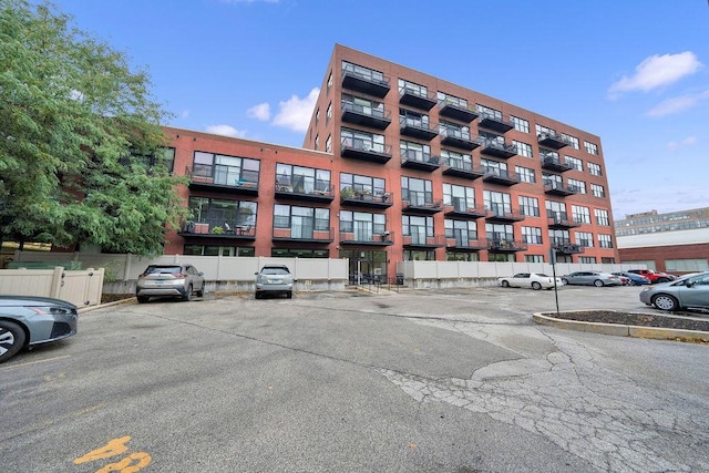 view of property with uncovered parking and fence