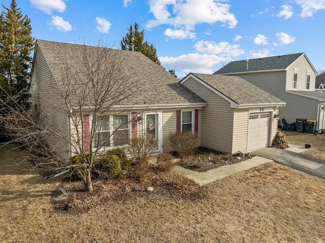 view of front of home featuring driveway, a garage, and roof with shingles