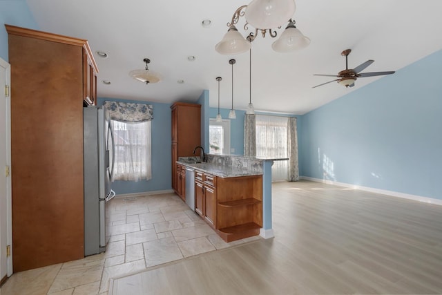 kitchen with light stone countertops, brown cabinets, a peninsula, stainless steel appliances, and open shelves