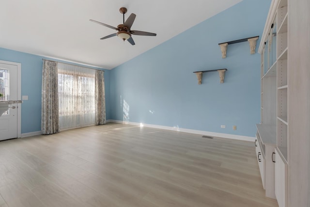 unfurnished living room with vaulted ceiling, a ceiling fan, baseboards, and light wood finished floors