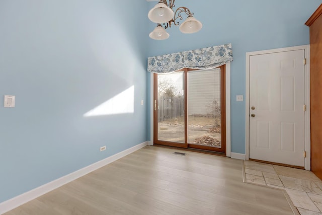 interior space featuring visible vents, baseboards, an inviting chandelier, and wood finished floors