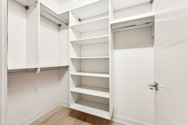 walk in closet with wood finished floors