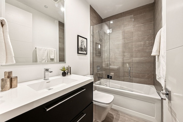 bathroom with enclosed tub / shower combo, toilet, and vanity