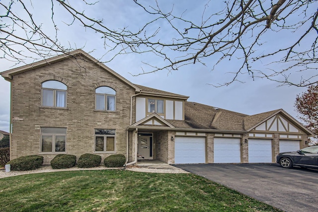 view of front of property with driveway, brick siding, an attached garage, and a front lawn