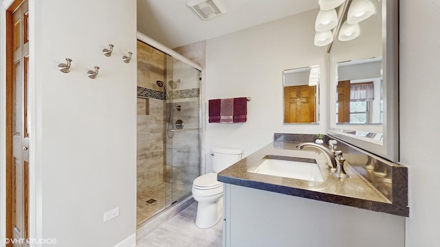 bathroom with visible vents, vanity, toilet, and a shower stall