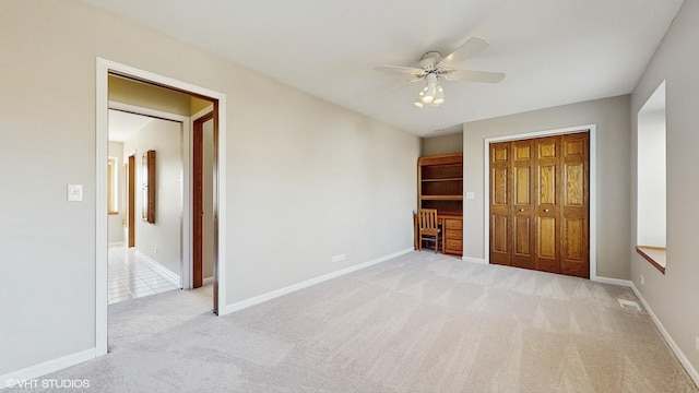 unfurnished bedroom featuring baseboards, visible vents, ceiling fan, a closet, and carpet flooring