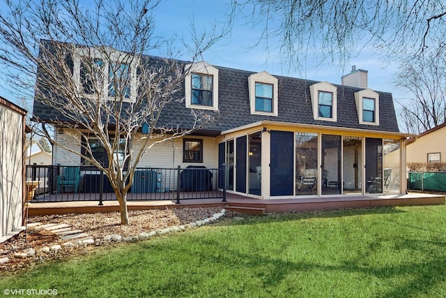 rear view of house with roof with shingles, mansard roof, a chimney, a yard, and a sunroom