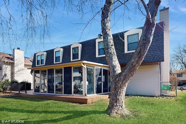 rear view of property featuring a yard, fence, a sunroom, and a shingled roof