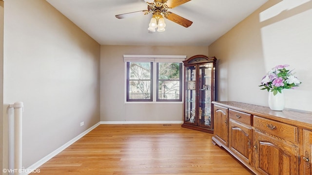 interior space with light wood-type flooring, baseboards, and a ceiling fan