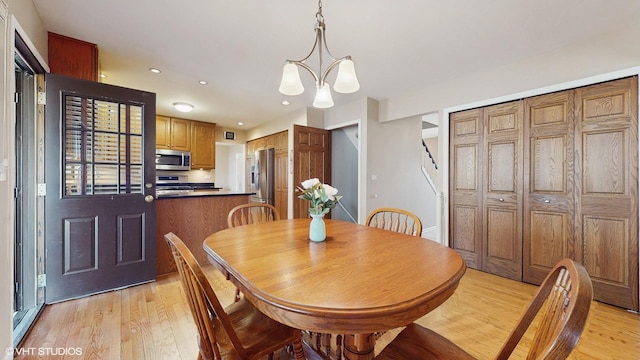 dining room featuring recessed lighting, stairway, an inviting chandelier, and light wood finished floors