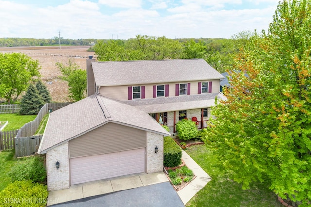 view of front of house featuring brick siding, fence, a shingled roof, and a garage