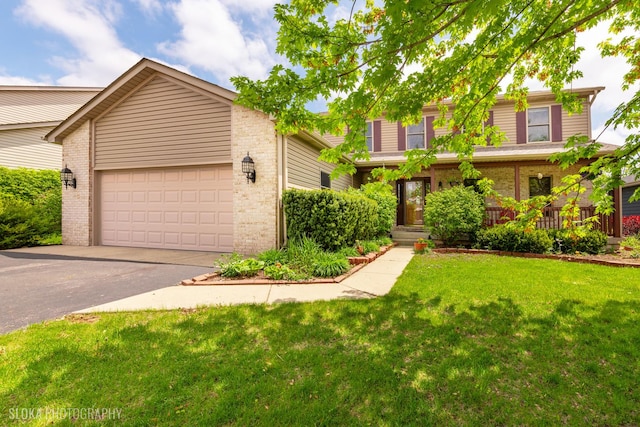 view of front of house with asphalt driveway, brick siding, a front yard, and an attached garage