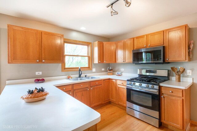 kitchen with stainless steel appliances, a sink, and light countertops