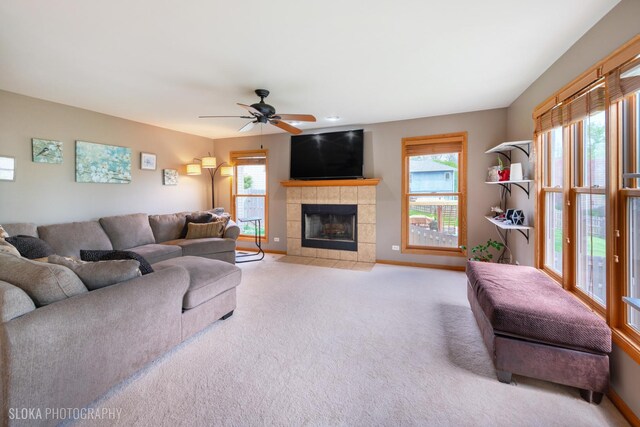 living area with a fireplace, carpet flooring, and a ceiling fan