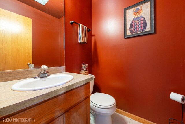 bathroom featuring toilet, tile patterned flooring, and vanity