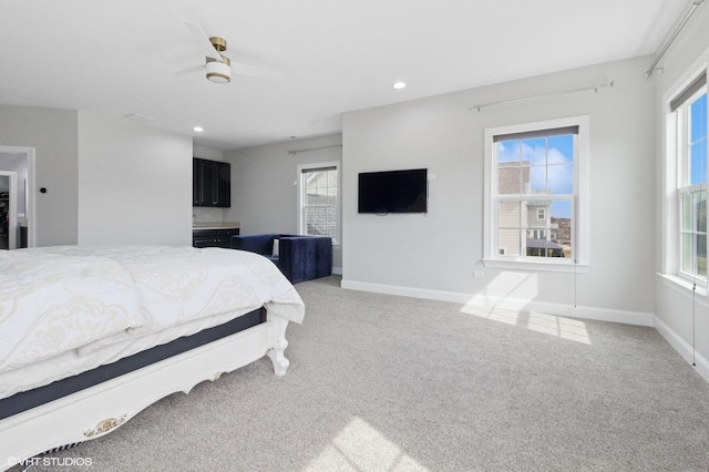 bedroom featuring baseboards, light colored carpet, and multiple windows