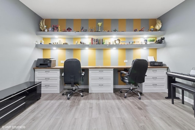 office area featuring wallpapered walls, built in study area, and light wood-style floors