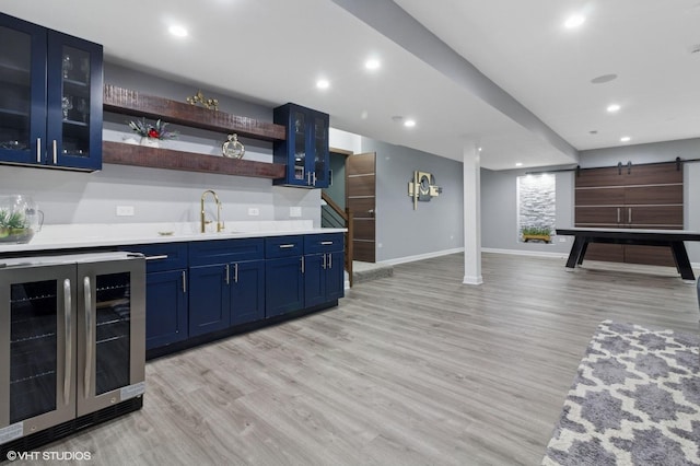 bar featuring recessed lighting, wine cooler, wet bar, a sink, and light wood-style flooring