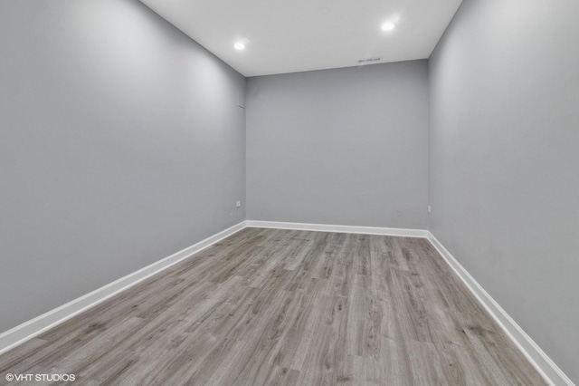 unfurnished room with recessed lighting, wood finished floors, visible vents, and baseboards