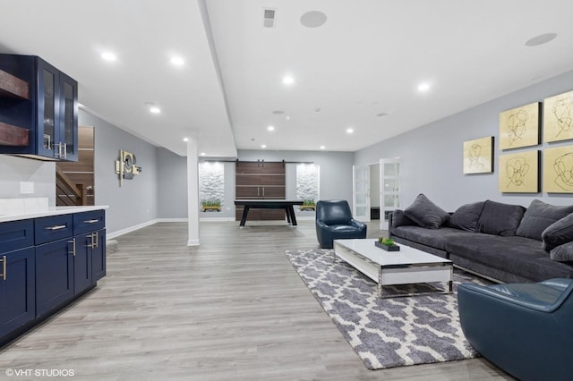 living area with recessed lighting, visible vents, light wood finished floors, and baseboards