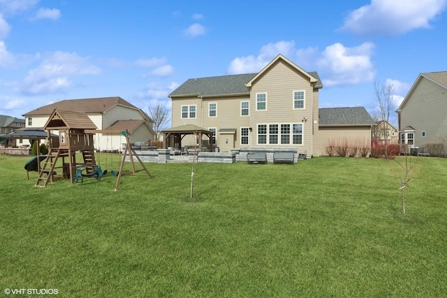 rear view of house featuring a gazebo, a lawn, and a playground